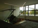 Gepoederlakte trap met treden in eik en een trapleuning-balustrade in glas met inox handgreep