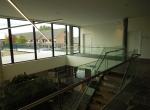 Gepoederlakte trap met treden in eik en een trapleuning-balustrade in glas met inox handgreep