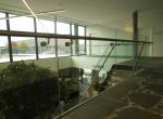 Gepoederlakte trap met treden in eik en een trapleuning-balustrade in glas met inox handgreep