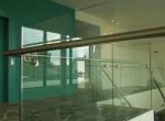 Gepoederlakte trap met treden in eik en een trapleuning-balustrade in glas met inox handgreep